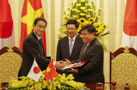 Bộ trưởng Bộ Kế hoạch và Đầu tư Nguyễn Chí Dũng (phải) và Ngoại trưởng Kishida bắt tay sau lễ ký kết.